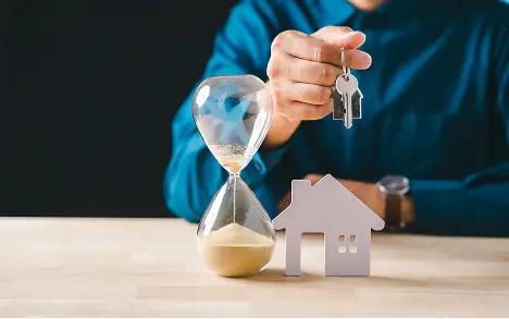 住まい探しからリフォームまでの時間短縮をイメージした住宅模型と砂時計